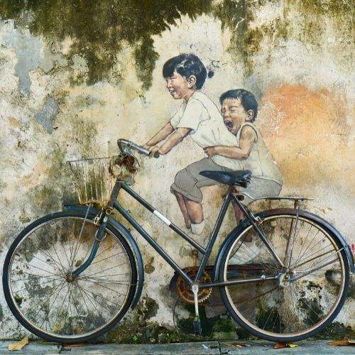 Drawing on the wall of two children in a bicycle