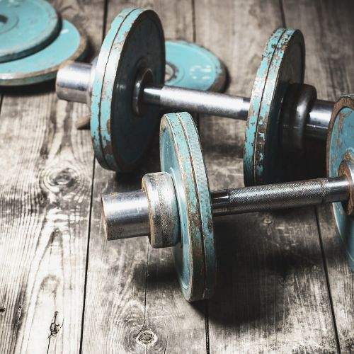 Old dumbbell with rusty blue color in wooden floor